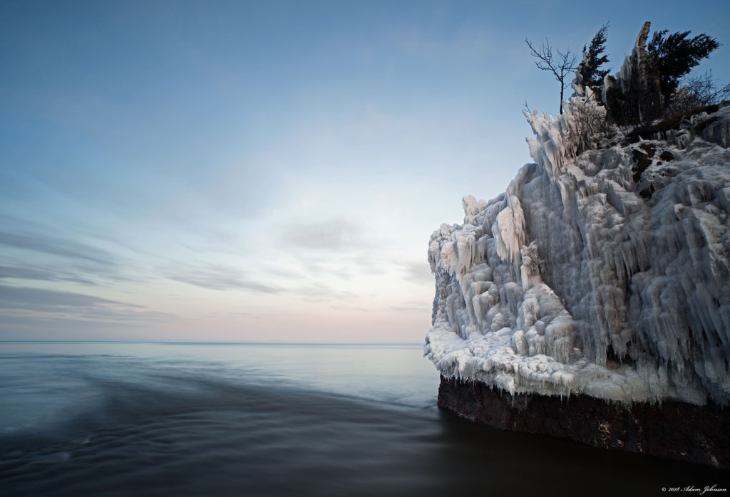 Ice covered rocks at the mouth of the Baptism river at twilight