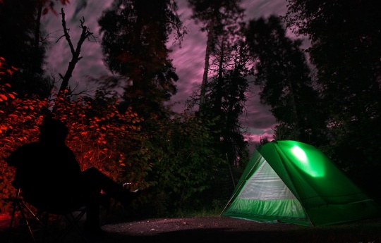"Camping Beneath a Full Moon" Man sitting next to campfire at Baptism River Campground - Tettegouche State Park