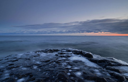 Ice cover rocks and the southern sky of Lake Superior at sunset | Split Rock Lighthouse State Park