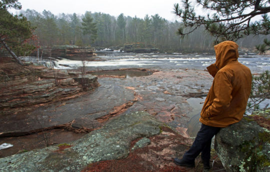 Sitting on rocks in the rain looking out at Big Spring Falls Banning State Park