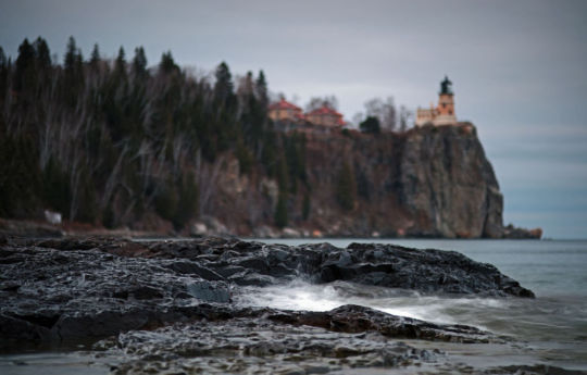 The rocky beach of Lake Superior with Split Rock Lighthouse in the background | Split Rock Lighthouse State Park