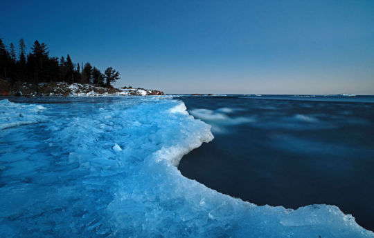 Lake Superior's waves crashing into icy shorelines after sunset Split Rock Lighthouse State Park