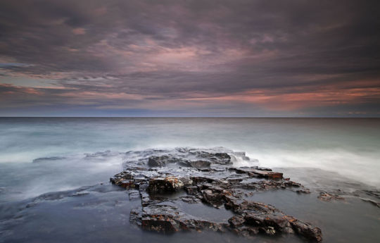 Waves rolling in on the rocky shoreline at sunset | Split Rock Lighthouse State Park