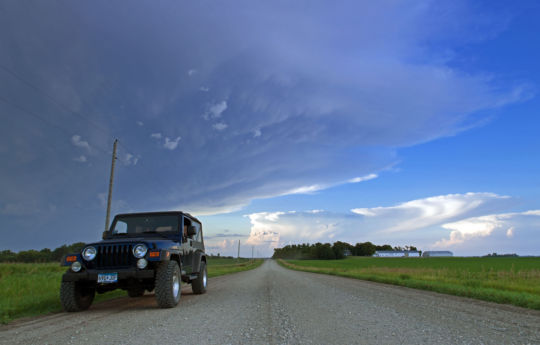 Jeep parked along the roadside with storms to the north, northwest and east | Renville County MN